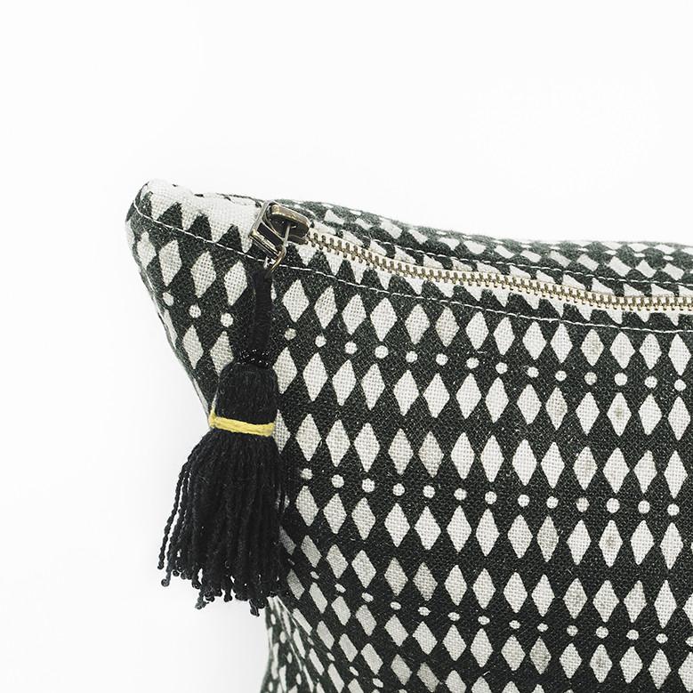 Detalle de pompón negro de colchoneta de lino lavado con estampado kalahari negro y blanco